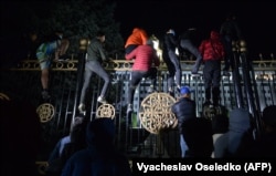 Protesters attempt to break through the gates of the White House -- the building that houses parliament and the president's office -- during a rally against the results of a parliamentary vote in Bishkek on October 5.