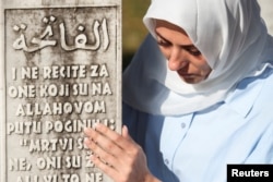 Боснійська мусульманка біля надгробного каменю у Меморіалі геноциду в Сребрениці, Поточари, Боснія і Герцеговина