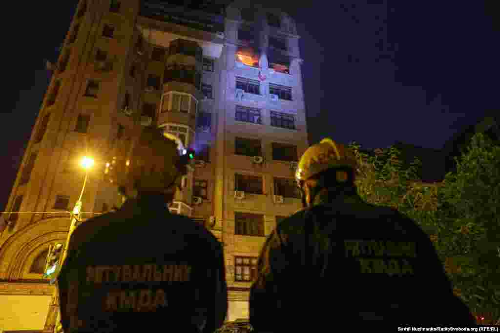 Рятувальники дивляться на пожежу в багатоквартирному будинку, спричинену російською атакою 10 липня 2025 року