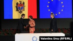 Moldovan Prime Minister Iurie Leanca (left) shakes hands with EU foreign policy chief Catherine Ashton as European Commissioner for Trade Karel de Gucht looks on after Leanca initialed Moldova's Association Agreement with the EU.