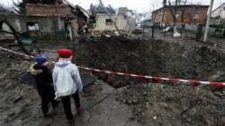 Bombardamentele rusești la scară extinsă au distrus infrastructura și orașele ucrainene. Acești copii se uită la cratetul creat de o explozie în Solonka, regiunea Lviv.