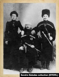 ზის სამუელ ჩავლეიშვილი. დგანან - მისი შვილი სამსონ ჩავლეიშვილი და სამსონის მეუღლე პელაგია მგელაძე