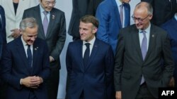 Kryeministri i Kanadasë Mark Carney (i pari majtas), presidenti i Francës Emmanuel Macron (në mes) dhe Kancelari gjerman Friedrich Merz, marrin pjesë në një fotografi familjare gjatë një sesioni plenar të Samitit të Liderëve të G20, në Johannesburg, 22 nëntor 2025.