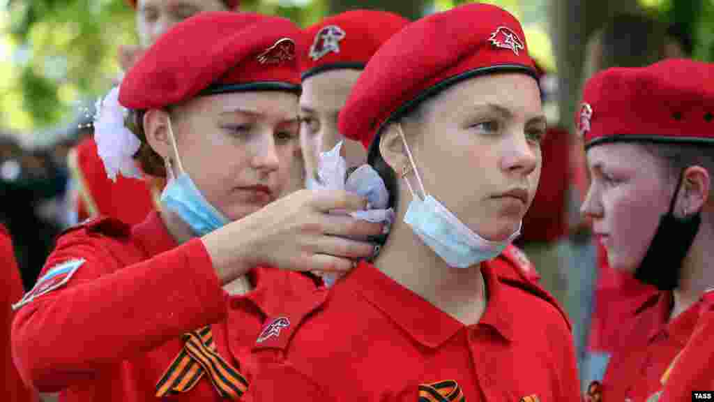 20 червня, Севастополь. Члени російської військово-патріотичної організації для школярів &laquo;Юнармія&raquo; беруть участь у репетиції параду, присвяченого 75-річчю закінчення Другої світової війни. При цьому правила захисту від вірусної інфекції не дотримані, хоча на той момент у Криму і Севастополі вже були зафіксовані випадки смерті, викликані коронавірусом або ускладненнями від нього. Правозахисники стурбовані не тільки самим фактом мілітаризації дитинства в Криму, але й тим, що вона триває під час пандемії COVID-19. За словами експерта &laquo;Кримської правозахисної групи&raquo; Ірини Сєдової, той факт, що на півострові продовжують &laquo;організовувати масові пропагандистські збори за участі дітей, яких одягають у форму &laquo;Юнармії&raquo;, та змушувати пропагувати службу в російській армії&raquo;, порушує права дітей на захист їхнього здоров'я і життя, зазначені в Конвенції про права дитини