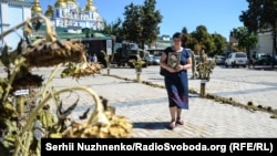 Панахида за загиблими під Іловайськом військовими на Михайлівській площі в Києві. Мама з портретом сина проходить по символічному «зеленому коридору», «дорозі смерті» (з назвами населених пунктів через які виходили війська з Іловайська), архівне фото, 2016 рік