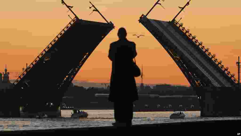 Muškarac gleda u podignuti most na reci Neva u Sankt Peterburgu.