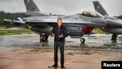 Polish Prime Minister Donald Tusk stands in front of F-16 fighter jets during a news conference on the threat posed by Russian drones on September 11.