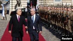 د هنګري وزیراعظم وېکتور اوربان (کیڼ لوري ته) د خپل اسراییلي سیال بنیامین نتنیاهو د هرکلي مراسمو پر مهال پر سره قالینه تېرېږي - د اپرېل درېیمې انځور.