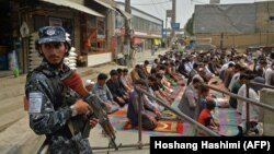 A Taliban fighter stands guard as Muslims offer Friday noon prayers at a Kabul mosque on October 1.
