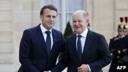 Cancelarul german Olaf Scholz (dreapta) a fost printre primii care a plecat de la summitul organizat de președintele francez Emmanuel Macron, nemulțumit de faptul că se discutau concepte de menținere a păcii în Ucraina ca după un acord, deși încă nu există o înțelegere.