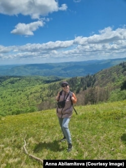 Переселенка на фоні Карпатських гір