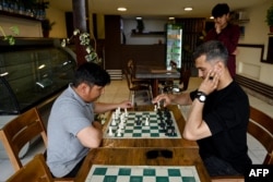 Muškarci igraju šah u kafiću Cupcake Coffee Shop u Kabulu neposredno prije nego što su talibani suspendovali ovaj sport u maju 2025. godine.