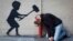 Graffiti în New York atribuit artistului Banksy.