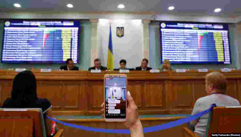 A journalist broadcasts a session of Ukraine's Central Electoral Commission live via a mobile phone in Kyiv, April 1, 2019. ( Reuters / Vasily Fedosenko)