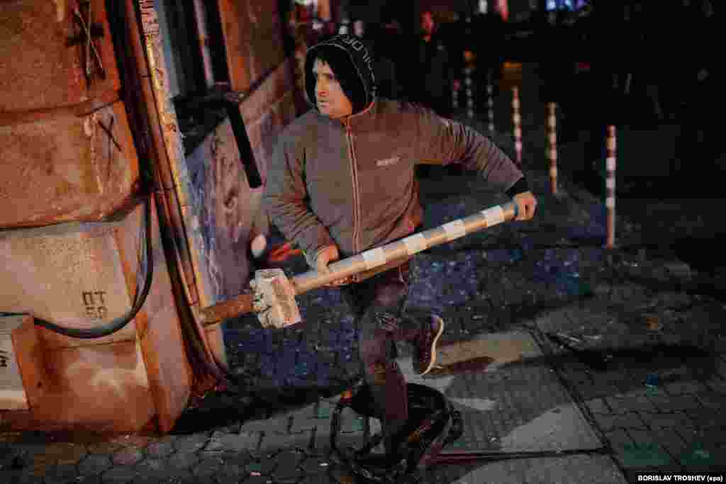 Demonstrant trči s metalnim parkirnim stubom tokom demonstracija u Sofiji, koje su postale nasilne u večernjim satima 1. decembra.