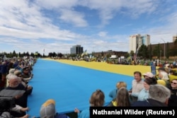 Трамп-Путин кездесуі қарсаңында және кездесу өткен күні Анкориджде Украинаны қолдау митингісі өтті. Наразылар Украина туын ұстап тұр. 15 тамыз 2025 жыл.