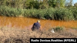 Рыбак на берегу Камышевахи, куда сливают шахтные воды. Они пришли с оккупированной территории и переполнили шахту в подконтрольном Украине Золотом. Сентябрь 2021 года