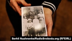 Правнучка Марії Жосул, однієї з відзначених Праведників народів світу, тримає фото прабабці з чотирма дітьми