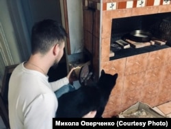 Микола вдома топить грубу. Хутір Дубовиця, Київська область. Лютий 2022 року