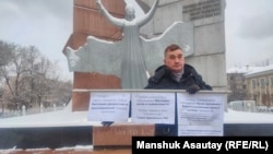 Активист Абай Ерекенов во время одиночного пикета у  монумента «Тәуелсіздік таңы» («Рассвет свободы») в Алматы. 15 февраля 2022 года