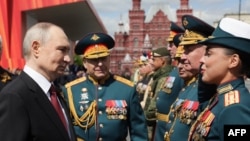 Într-o fotografie distribuită de agenția de stat rusă Sputnik, președintele rus Vladimir Putin îi salută pe comandanții militari după parada militară de Ziua Victoriei din Piața Roșie - Moscova, 9 mai 2025.