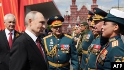Vladimir Putin înfățișat într-o fotografie difuzată de Sputnik, salutându-și comandanții militari după parada de Ziua Victoriei în Piața Roșie, pe 9 mai 2025