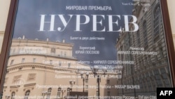 The Bolshoi Theater building is reflected in a plaque announcing the Nureyev ballet premiere in Moscow.