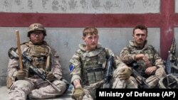 Militari americani și britanici fac o pauza, în mijlocul eforturilor de evacuare a civililor de pe aeroportul din Kabul, Afganistan, 21 august 2021.