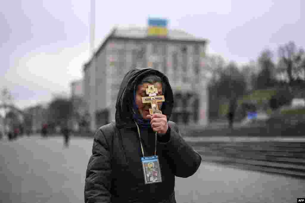 O femeie se roagă în Piața Independenței din Kiev, joi dimineață, după atacarea Ucrainei de către armata rusă. &nbsp;