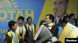 "Нұр Отан" партиясының лидері Нұрсұлтан Назарбаевтың суретінің алдында тұрған партия мүшелері. 16 января 2012 года.
