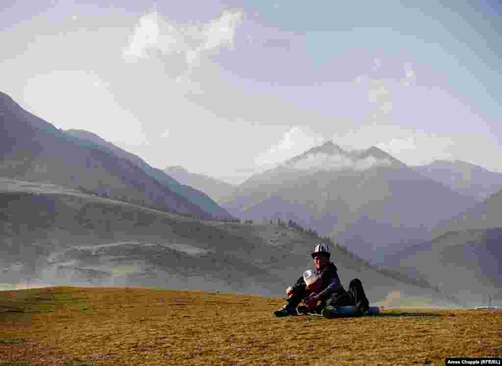 Улгайган достор күндүн батканын карап ыракаттанып отурат.