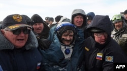 Ailing? Russian space agency rescuers help cosmonaut Aleksandr Kaleri shortly after his landing near the town of Arkalyk, in Kazakhstan on March 16.