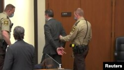 Бывшего полицейского Миннеаполиса Дерека Шовина выводят из зала суда после оглашения вердикта присяжных, 20 апреля 2021 года
