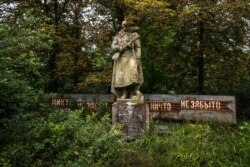 Розсоха, Україна. Шістдесят вісім осіб з цього села загинули під час війни. Цей пам'ятник споруджений над братською могилою загиблих тут. На плакаті за статуєю написано: «Ніхто не забутий, ніщо не забуте»