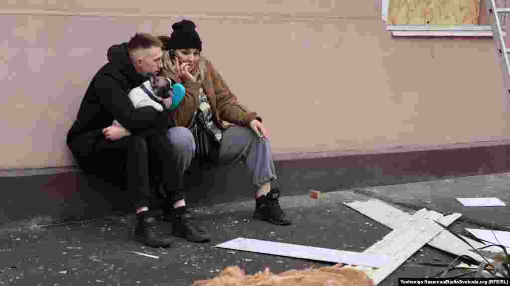 Пара місцевих мешканців з домашнім улюбленцем під стінами власного під'їзду, що зазнав руйнувань через ракетний удар російських військ. Запоріжжя, 18 січня 2025 року &nbsp;