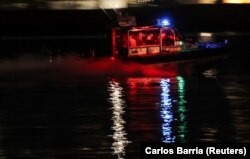 O barcă de salvare caută victime în râul Potomac, în apropierea Aeroportului Ronald Reagan din Washington.