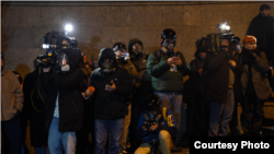 ალექსანდრე ქეშელაშვილი აქციაზე. აცვია ლურჯი ქურთუკი, ახურავს ჩაფხუტი, უკეთია აირწინაღი. თან აქვს ორი კამერა და ტელეფონი. ფოტო გადაღებულია 28 ნოემბრის ღამით, დაკავებამდე ცოტა ხნით ადრე