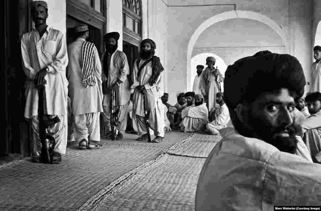 Outside the front door of the late tribal leader Nawab Akbar Khan Bugti's home, several Bugti tribesmen stand guard, while others wait for an audience with their chieftain.