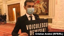 În imagine, Gabriel Zetea, deputat PSD, la Parlament, cu o pancartă prin care cere demisia ministrului Sănătății, Vlad Voiculescu. 