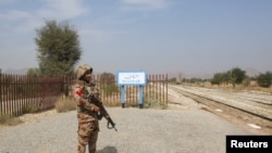 د پاکستان د پوځ یو سرتېری په بولان کې پر مساپر لېږدوونکي اورګاډي تر برید وروسته پر یو تمځي پهره کوي - د مارچ ۱۲مې انځور. 