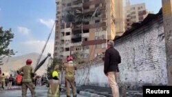 Яке аз биноҳои истиқоматии осебдида дар ҳамлаи Исроил.