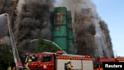 Vatrogasci gase požar koji je zahvatio bambusnu skelu na stambenim soliterima u Hongkongu, 27. novembar 2025.