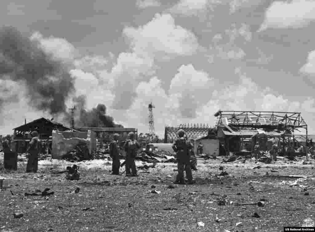 Pușcași marini americani după sosirea pe aerodromul japonez de pe insula Tinian, în iulie 1944.Insula a fost cucerită de la japonezi în august 1944, în perioada în care armata SUA lupta în Pacific pentru cucerirea Japoniei continentale, în faza finală a celui de-al Doilea Război Mondial.