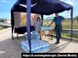 Пункт раздачи воды российским туристам, застрявшим в пробках у Керченского моста во время курортного сезона, 14 июля 2025 год