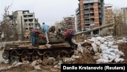 Tenk na raskrsnici ispred uništene zgrade u sarajevskom naselju Kovačići, februar 1996. 