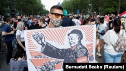 A demonstrator holds a sign depicting Hungarian Prime Minister Viktor Orban as Mao Tse-tung during a protest against the planned Chinese Fudan University campus in Budapest on June 5.