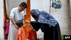 په پېښور کې یو روغتیايي کارکوونکې ماشومانو ته د ګوزڼ مخنیوي څاڅکي ورکوي - انځور له ارشيفه.