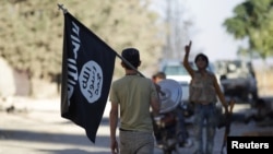 FILE: A rebel fighter takes away a flag that belonged to Islamic State militants in Syria's northern Aleppo Governorate in October.