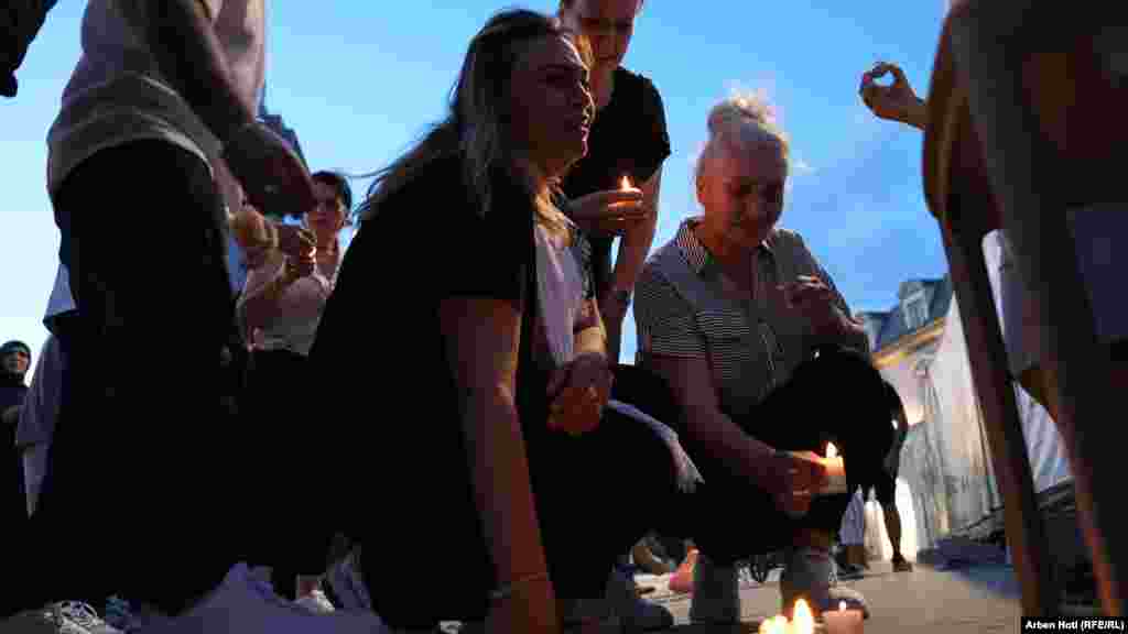 Motra e Agonit shihen tejet e mërzitur në ceremoninë e ndezjes së qirinjve.