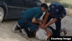 Милиция инспекторлары фермер Сирожиддин Құрбановты күштеп әкетпек болып жатқан сәт (видеодан скриншот)